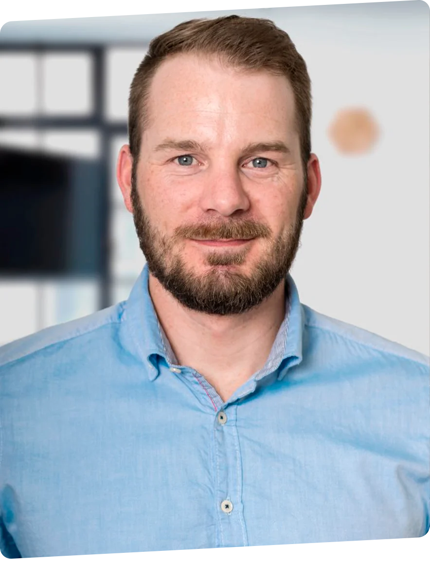 Portrait des Inhabers von PERFEMO Elektrotechnik, lächelnd vor neutralem Hintergrund