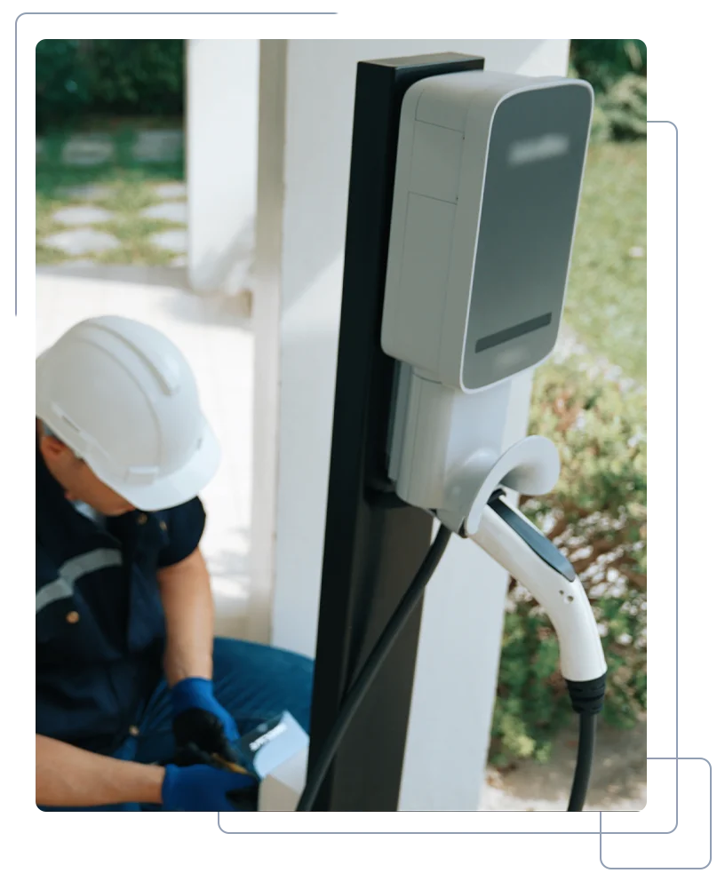 Elektrotechniker installiert Wallbox an Hauswand für Elektrofahrzeug-Ladung